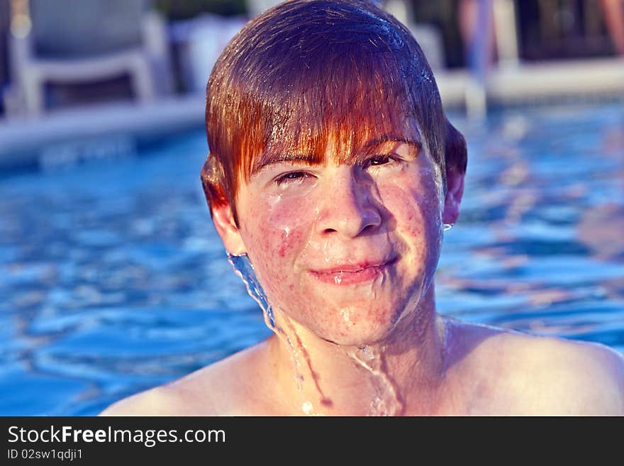 Child with red hair has fun in the outdoor pool. Child with red hair has fun in the outdoor pool