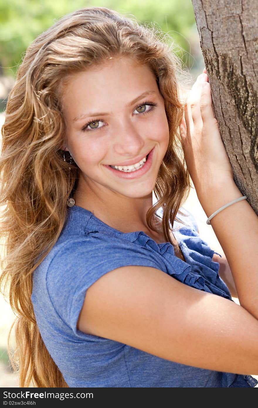 Portrait of a beautiful modern woman holding tree at park. Portrait of a beautiful modern woman holding tree at park