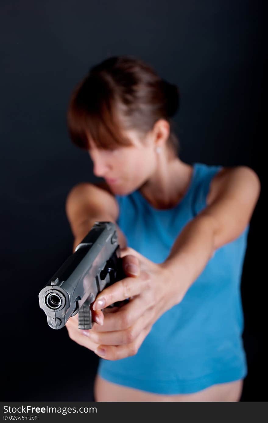 Woman with gun on black background