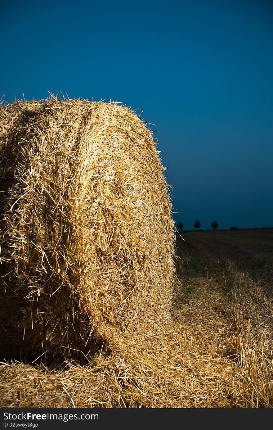 Summer sunset field stack of dry up hay