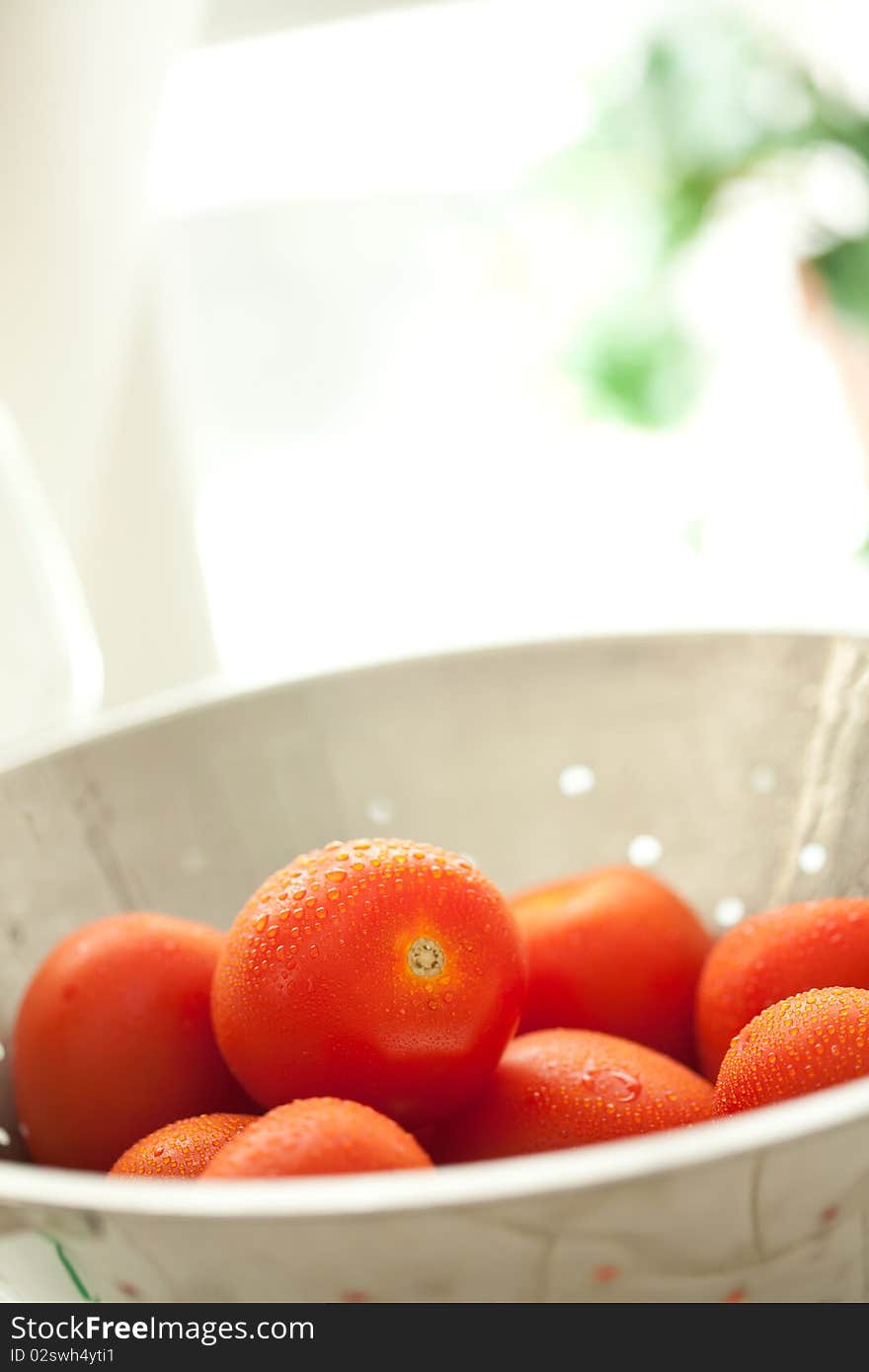 Fresh, Vibrant Roma Tomatoes in Colander with Wate