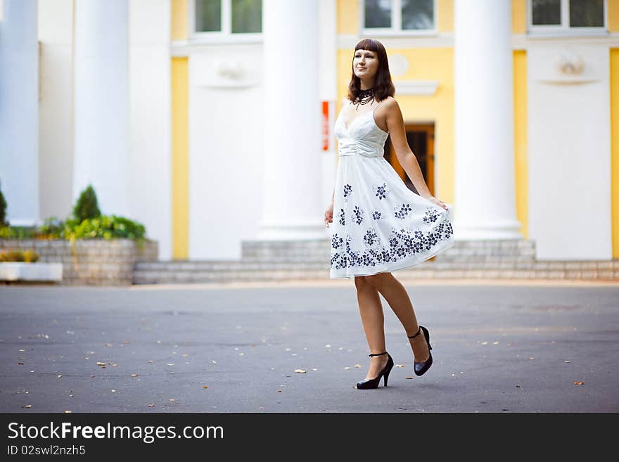 Young beautiful girl stands in front of house