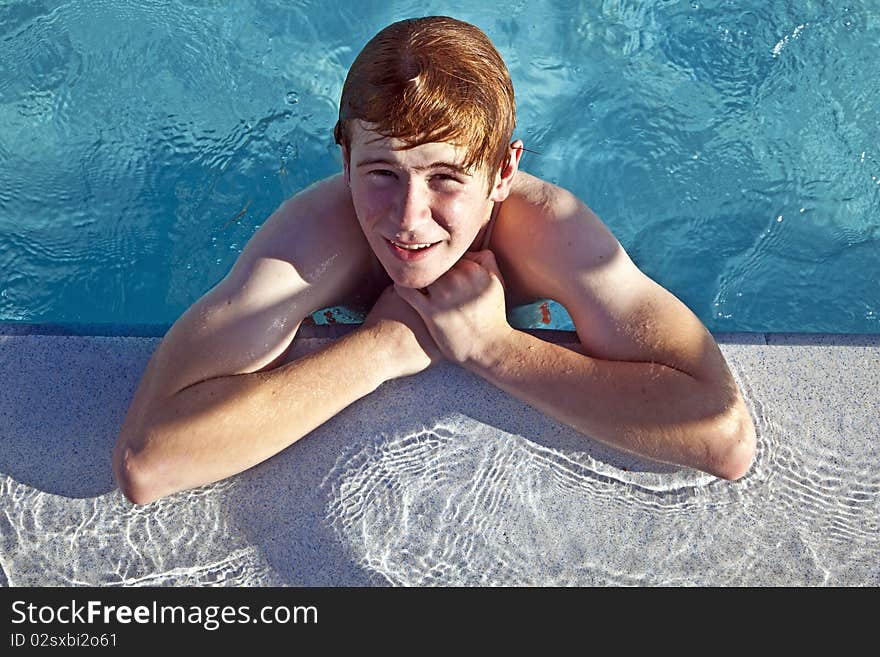 Boy Rests On His Ellbow At The Edge Of The Pool