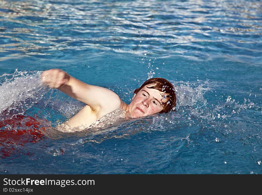 Young boy is crawling in the pool