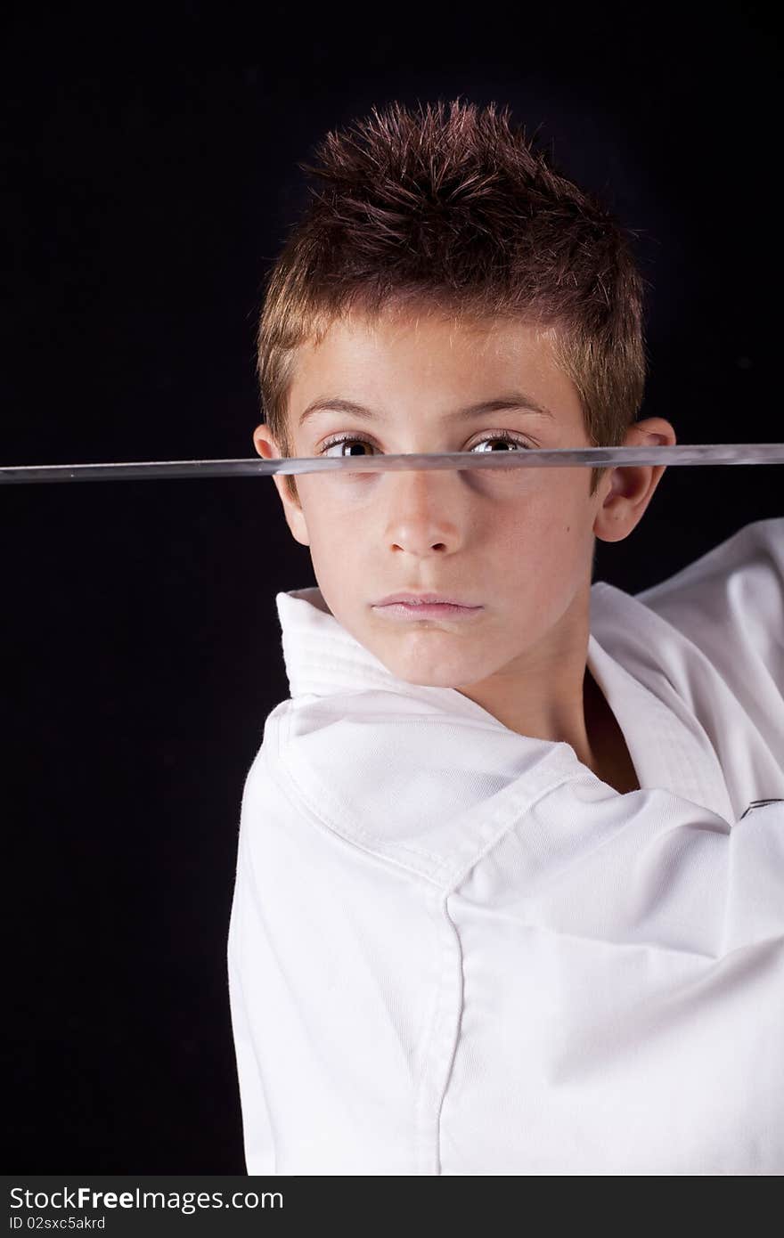 Young boy concentrated training in karate with a sword. Young boy concentrated training in karate with a sword