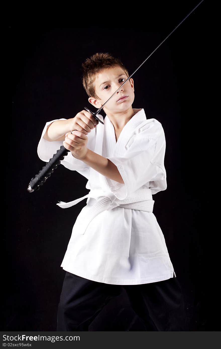 Young boy concentrated training in karate with a sword. Young boy concentrated training in karate with a sword