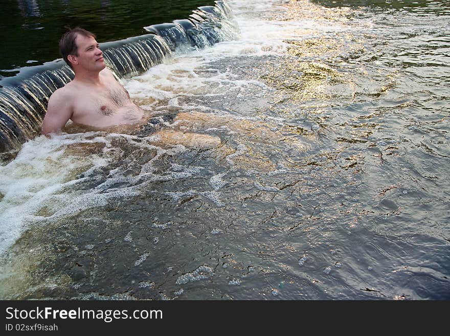 Man sitting in nature spa water