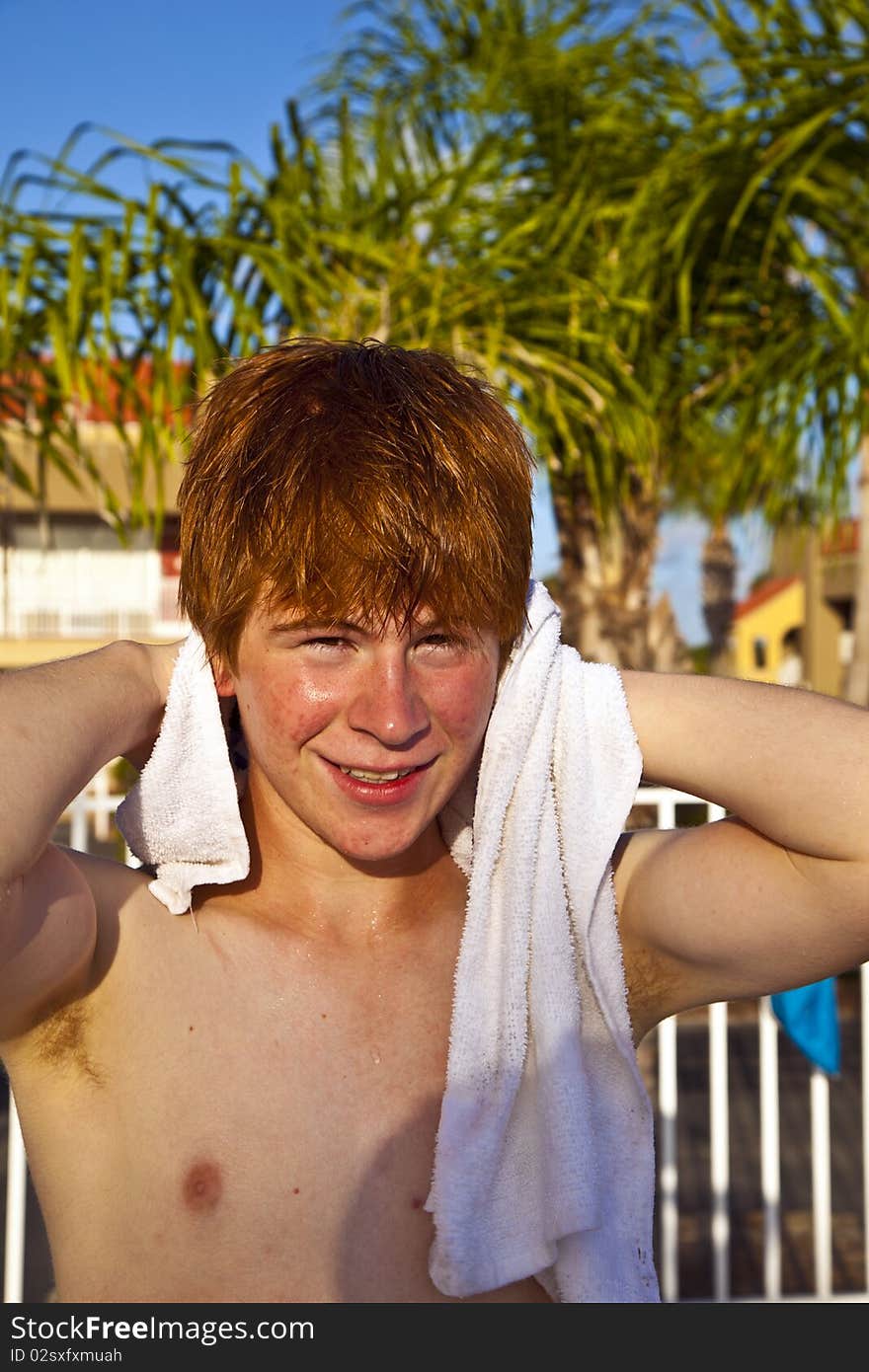 Boy with red hair using a towel after swimming in a pool. Boy with red hair using a towel after swimming in a pool