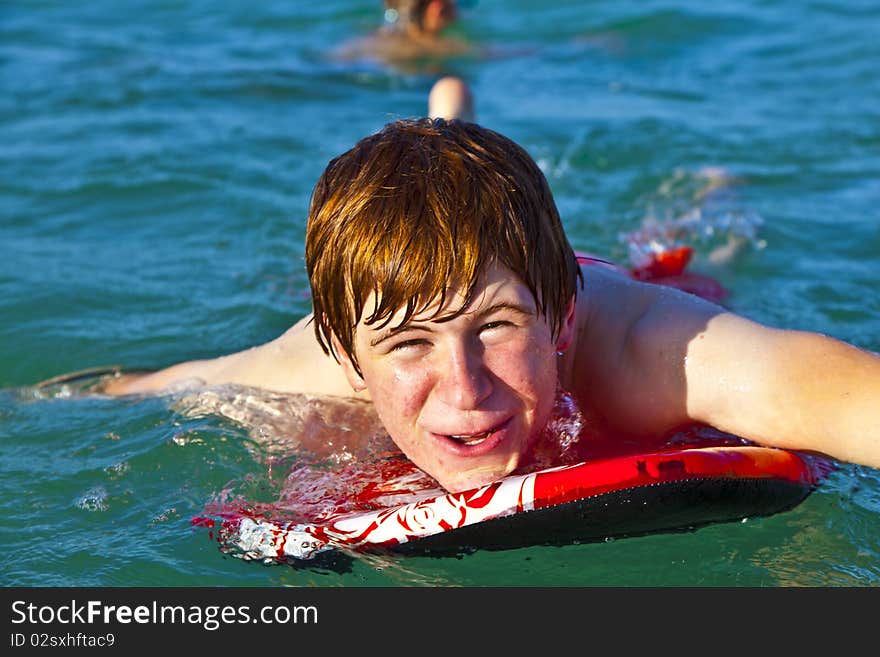 Boy is crawling on the surfboard