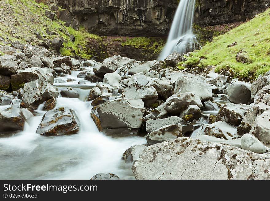 Motion blurred image of a beautiful waterfall in a river gorge in Iceland