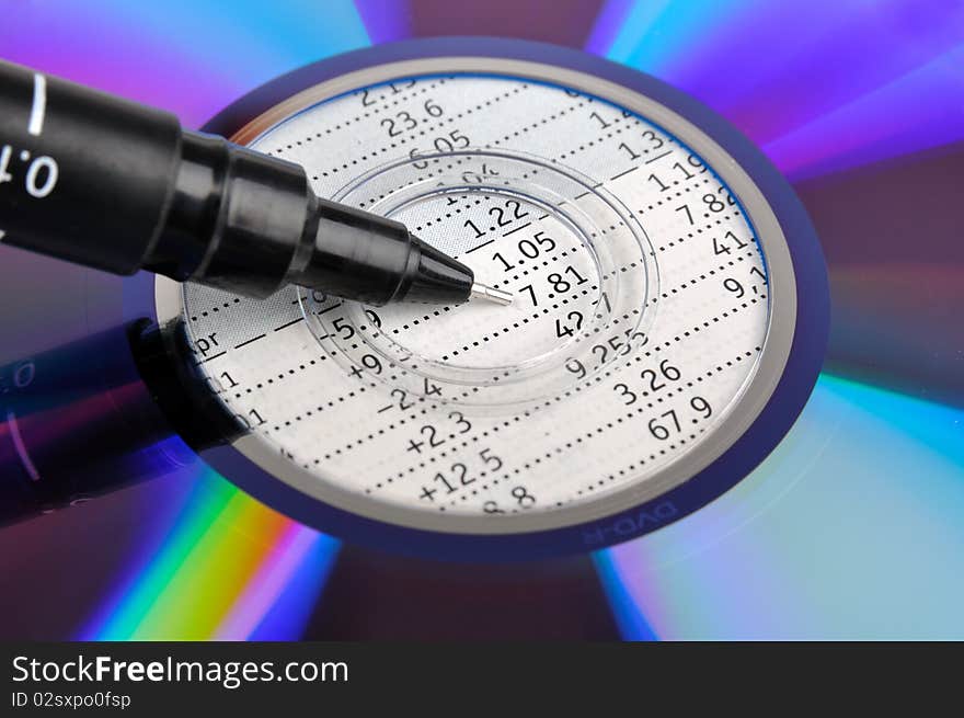 A colorful compact disk putting on a datasheet, with a pen point to center, means data and analysis business concept. A colorful compact disk putting on a datasheet, with a pen point to center, means data and analysis business concept.