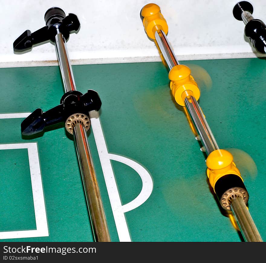 Black and yellow foosball players spinning to take a shot. Black and yellow foosball players spinning to take a shot.