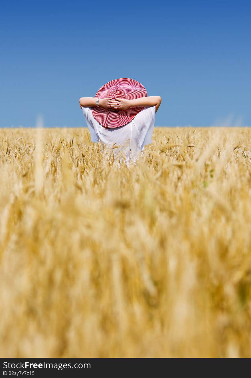 Beautiful woman with hat in wheat meadow on sunny day