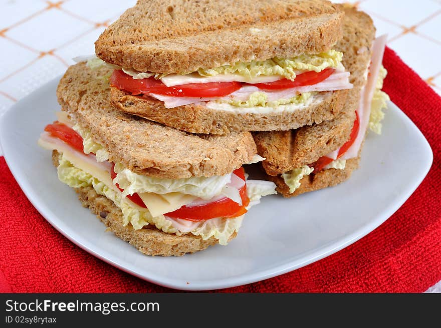 Fresh and delicious classic club sandwich over a white glass dish. Fresh and delicious classic club sandwich over a white glass dish