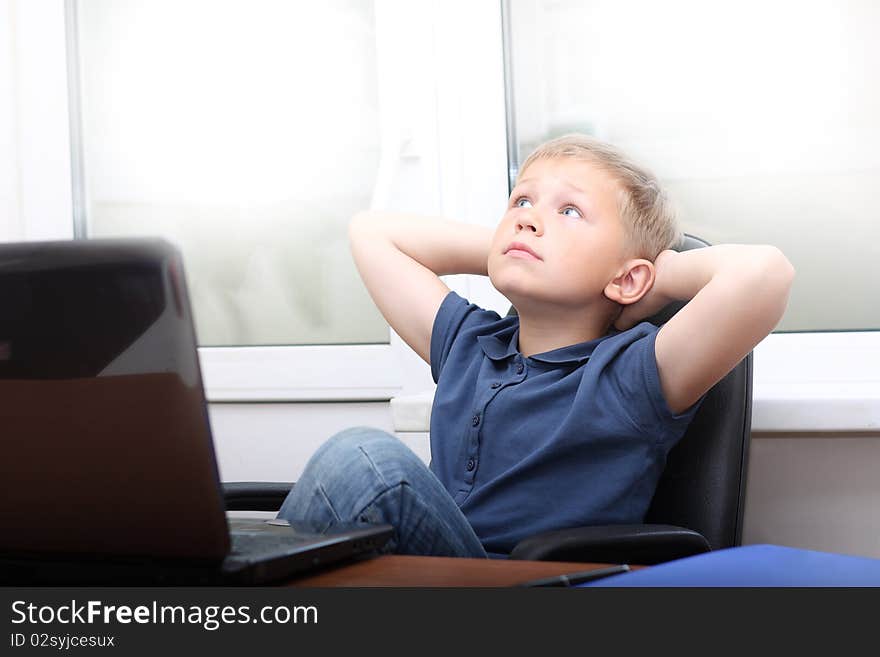 Relaxed young boy near laptop. Relaxed young boy near laptop.