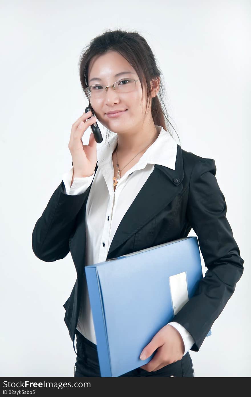 A Smiling business girl  in glasses with a cell phone and folders of documents. A Smiling business girl  in glasses with a cell phone and folders of documents