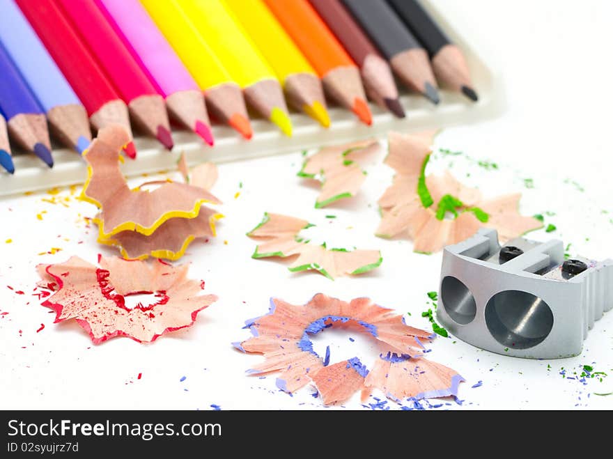 Colored pencils, pencil shavings and sharpener. Colored pencils, pencil shavings and sharpener