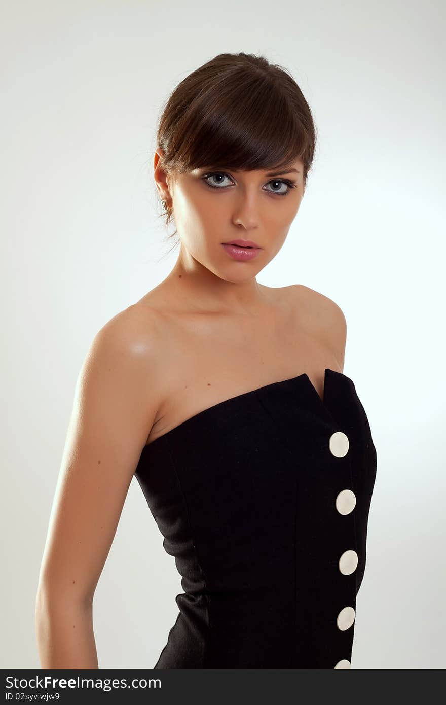 Beautiful fashion model in a black dress posing for the camera