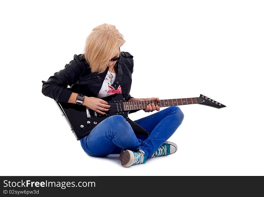 Passionate rock girl playing an electric guitar sitting down