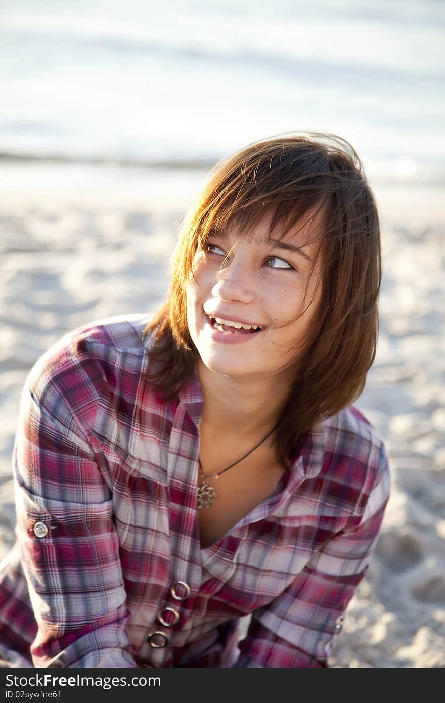 Portrait of beautiful brunet girl. Beach photo.