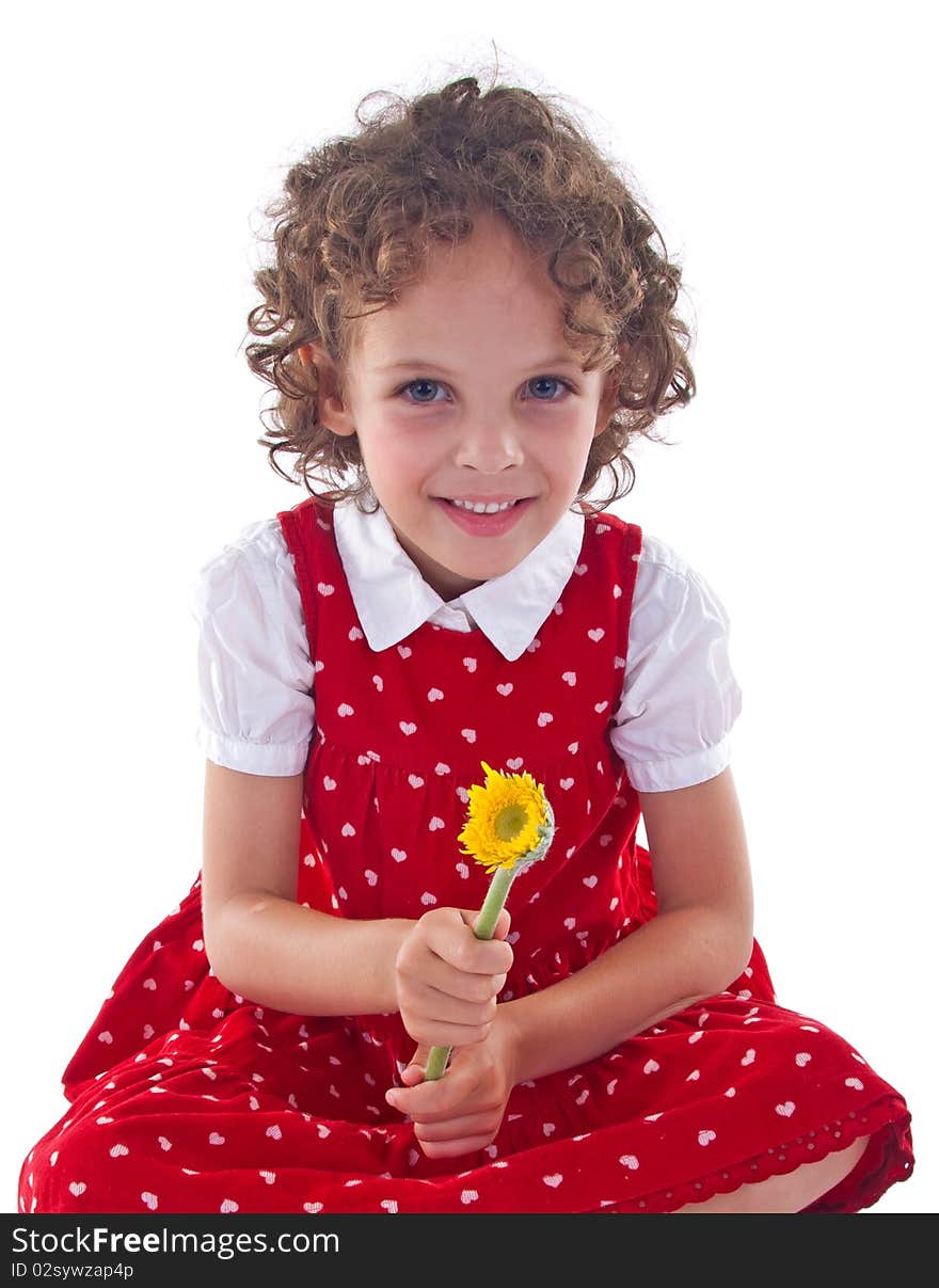 Little girl wearing red dress is stitting with a flower in her hand