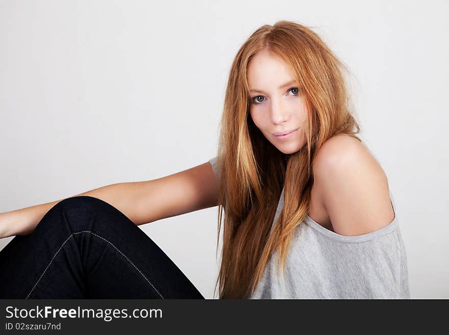 Side view of a beautiful young woman with red hair posing in stylish clothing. Horizontal shot. Side view of a beautiful young woman with red hair posing in stylish clothing. Horizontal shot.