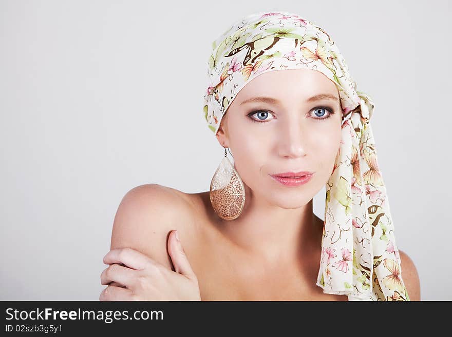 Head and shoulders portrait of an attractive young woman wearing a headscarf and ornate earrings. Horizontal shot. Head and shoulders portrait of an attractive young woman wearing a headscarf and ornate earrings. Horizontal shot.