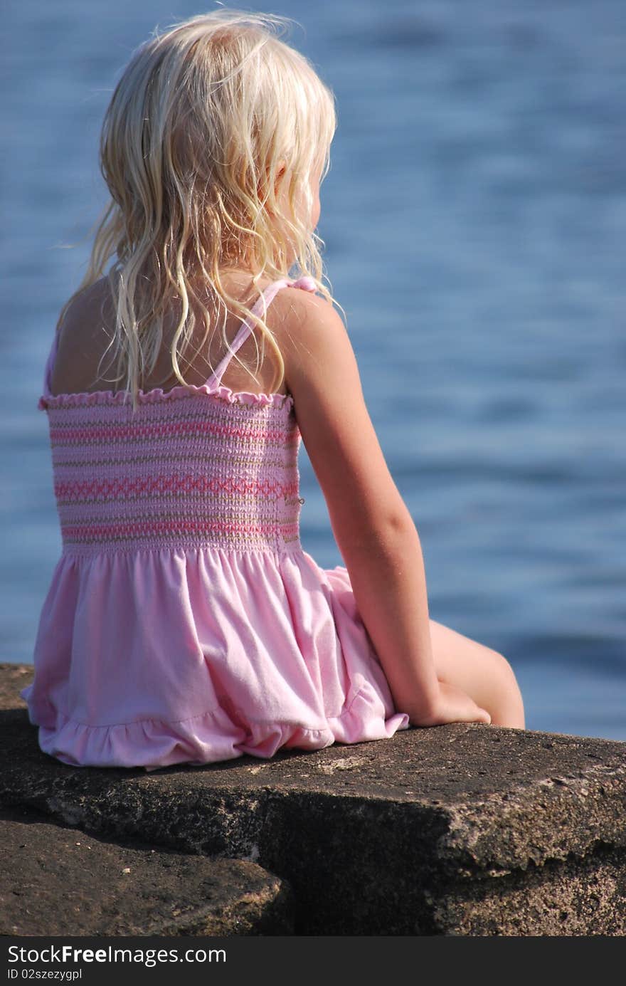 Little blond girl watching the ocean. Little blond girl watching the ocean