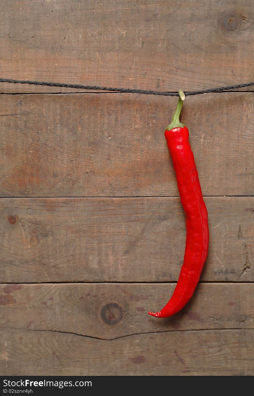 Red chili pepper hanging on wooden background with rope. Red chili pepper hanging on wooden background with rope