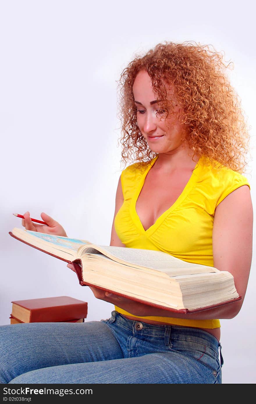 Studying happy young woman reading her book for school