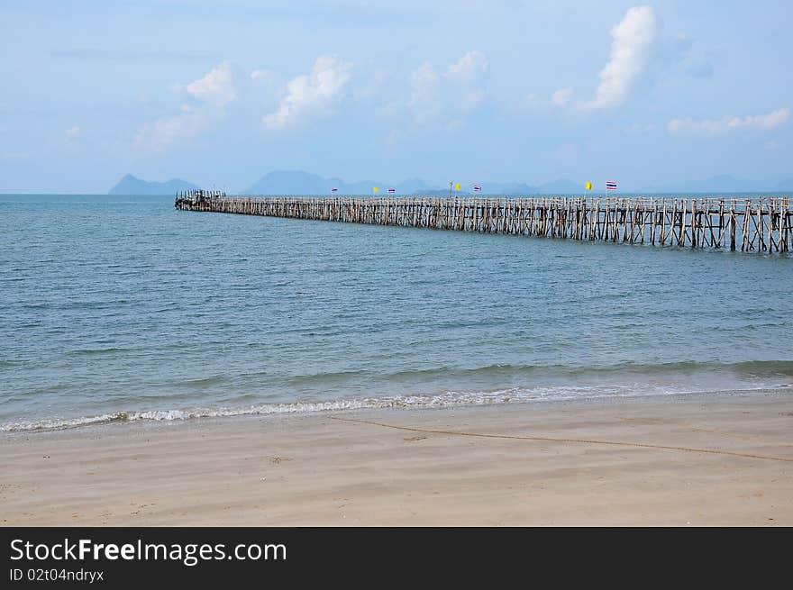 Long wooden pier into the sea for Ferry Boat in Choomporn, Thailand