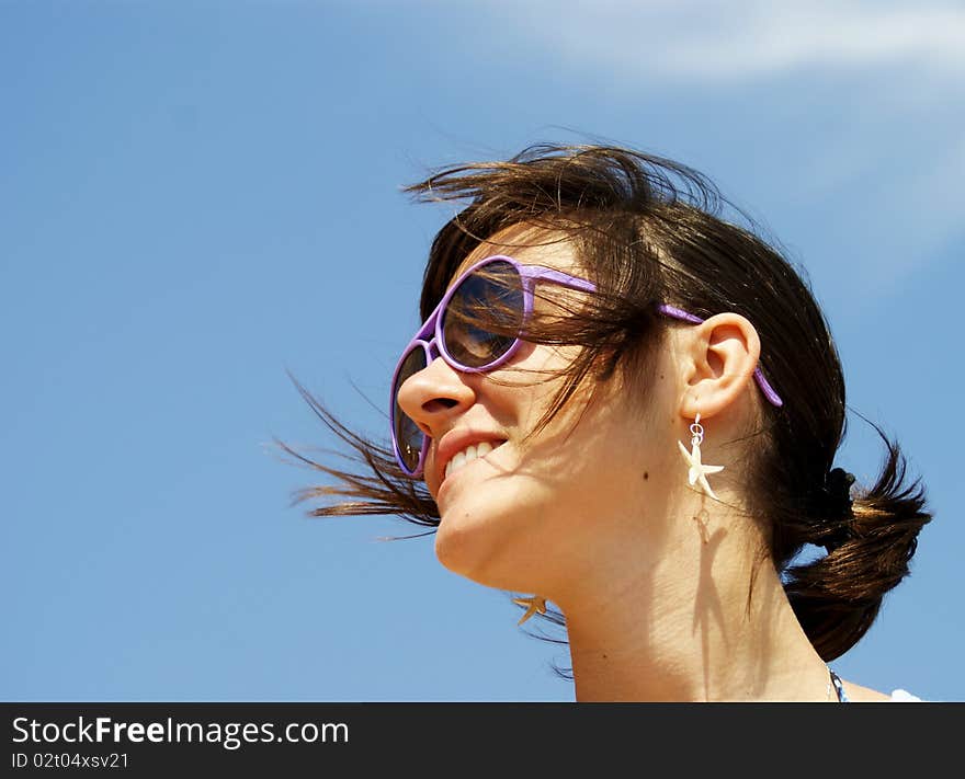 Portrait of a young woman smiling that wears sunglasses and looking somewhere far away. Portrait of a young woman smiling that wears sunglasses and looking somewhere far away