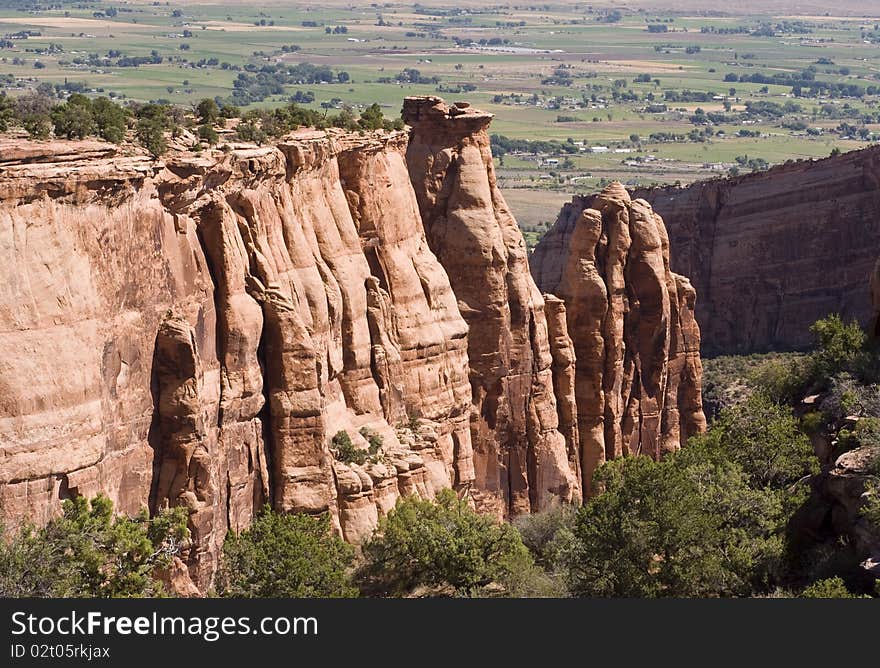 Sandstone formations along the canyon walls in Colorado National Monument with the Colorado River valley in the background.