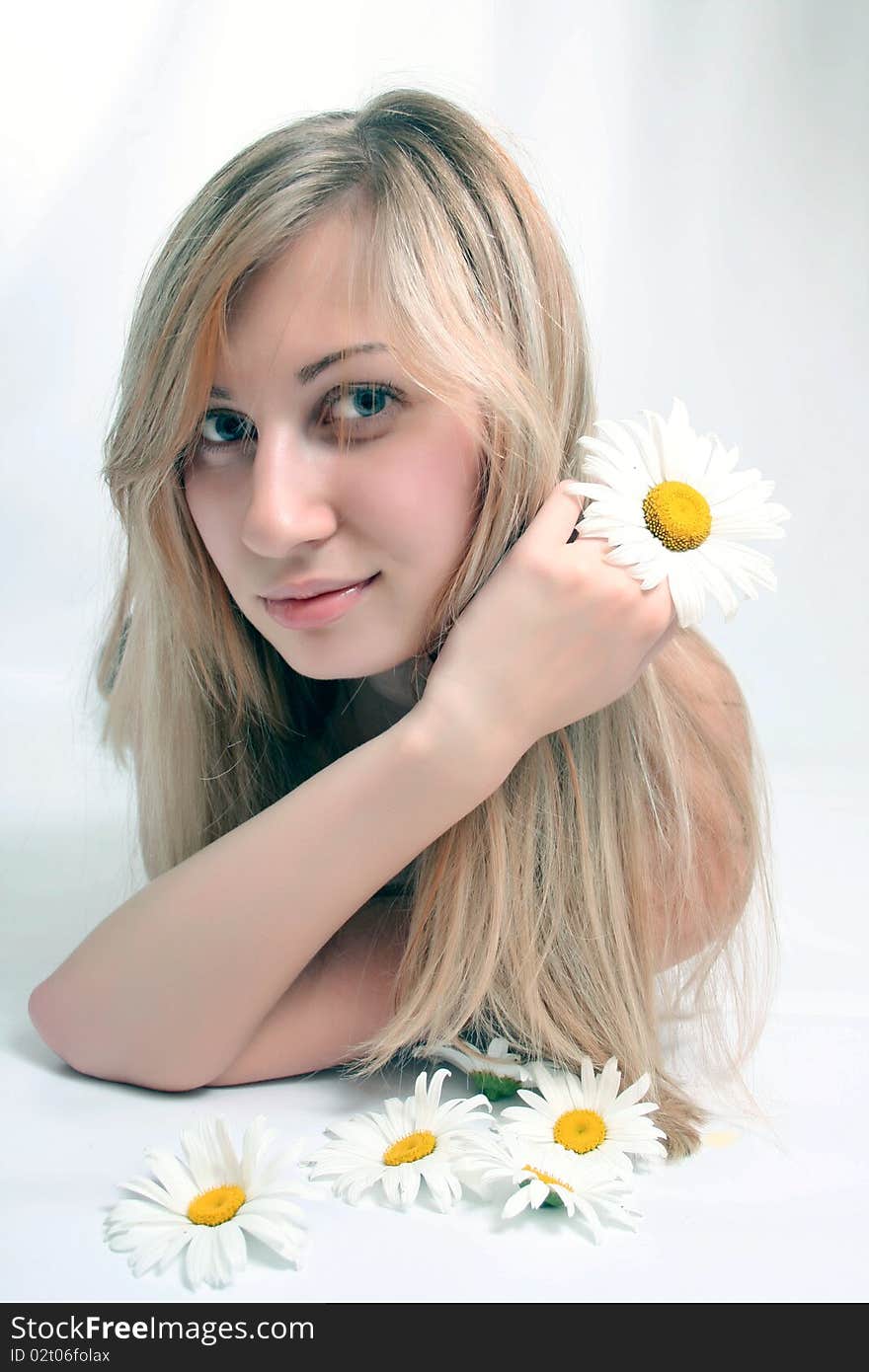 Close-up portrait of a fresh and beautiful woman with chamomile