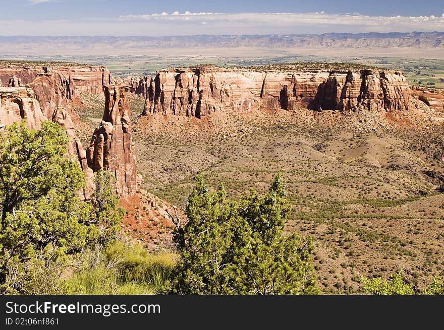 Sandstone formations along the canyon walls in Colorado National Monument with the Colorado River valley in the background.