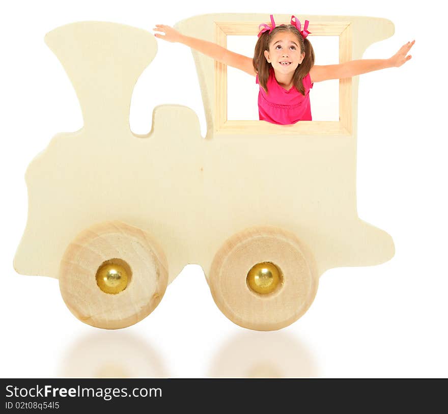 Beautiful 7 year old american girl riding in wooden toy train engine over white background with reflection. Beautiful 7 year old american girl riding in wooden toy train engine over white background with reflection.