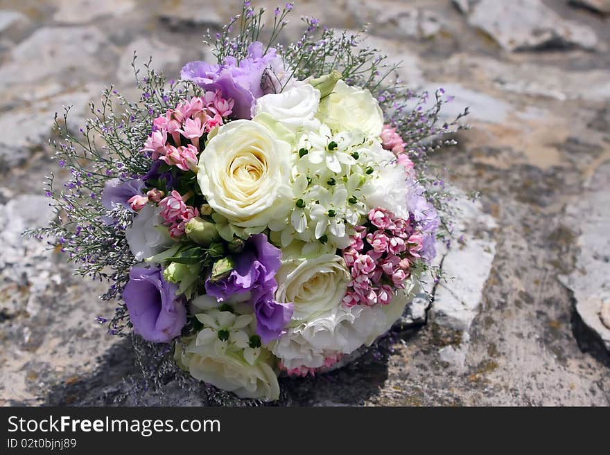 Colorful wedding Bouquet of Field Flowers on the stone wall