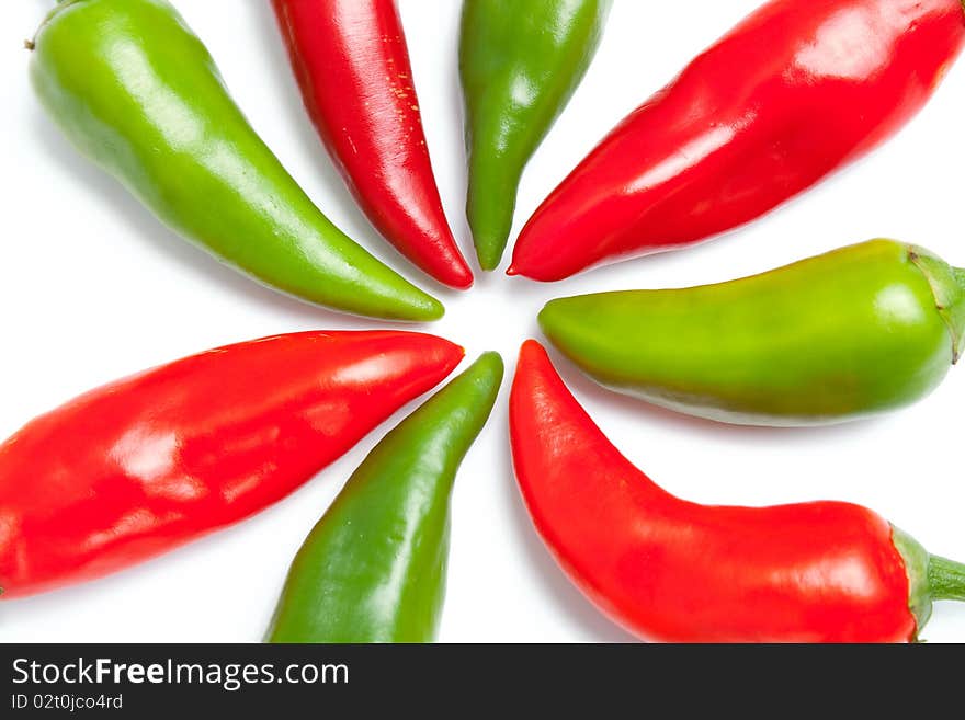 Green and red hot peppers close up arranged in shape of sun rays isolated on white background. Green and red hot peppers close up arranged in shape of sun rays isolated on white background