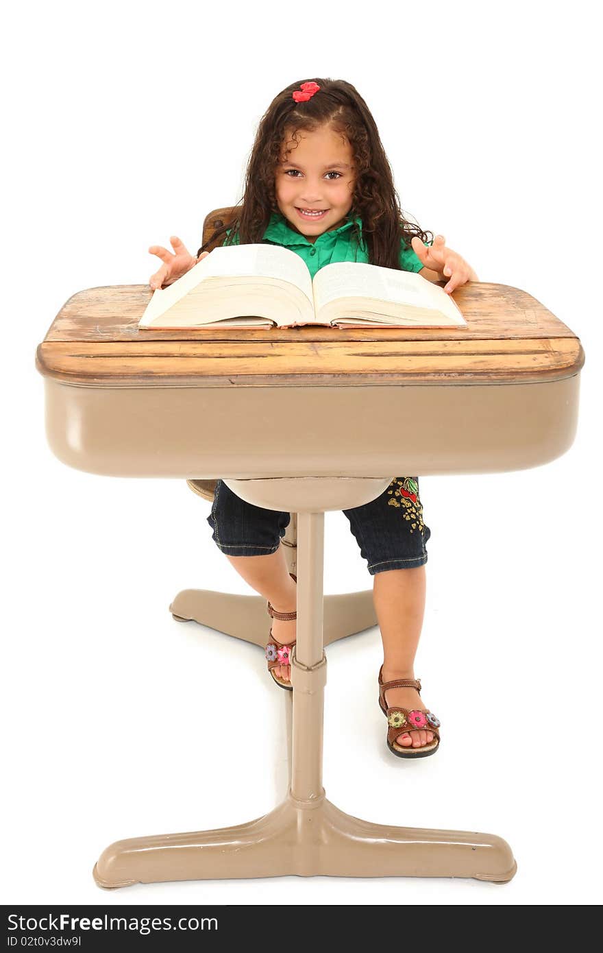 Happy three year old hispanic girl sitting in school desk over white background. Happy three year old hispanic girl sitting in school desk over white background.