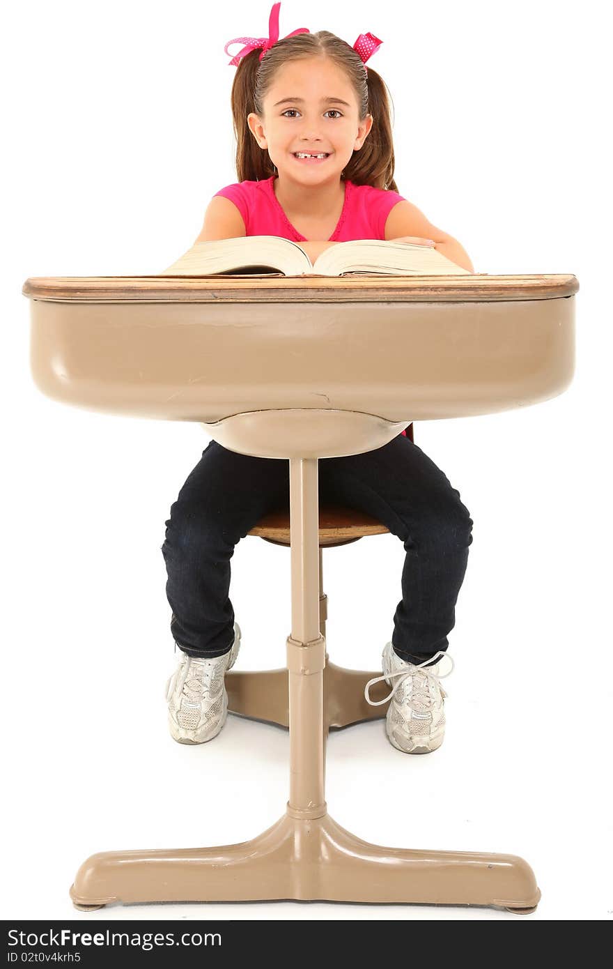 Beautiful 7 year old american girl sitting in school desk over white background. Beautiful 7 year old american girl sitting in school desk over white background.