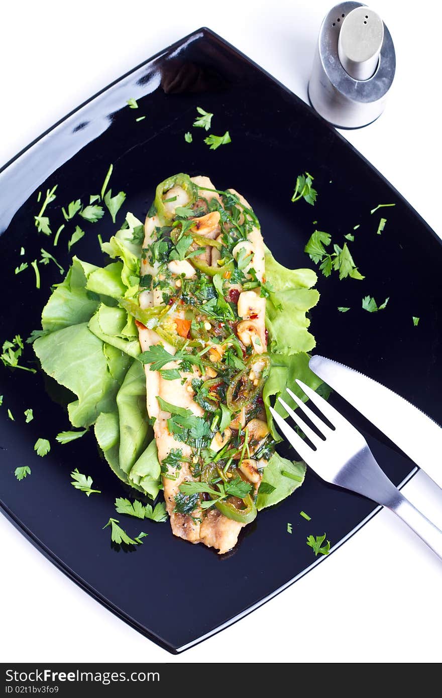 Oven cooked fish on a black plate