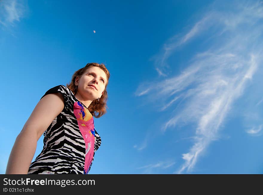 A beautiful girl on a background of blue sky. A beautiful girl on a background of blue sky