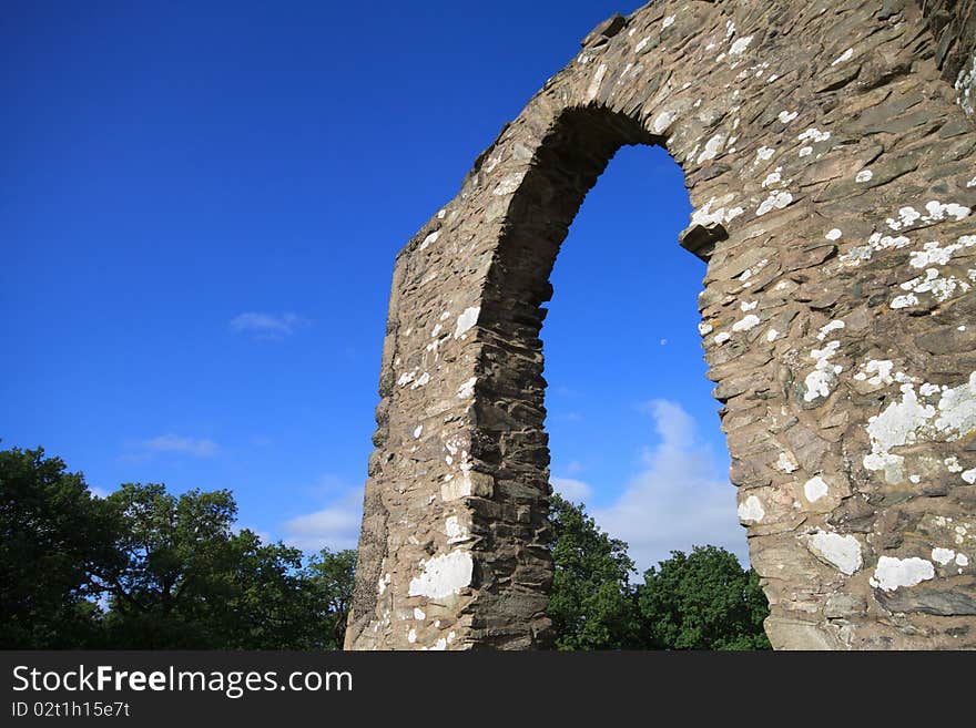 Ancient stone archway against a brilliant blue sky