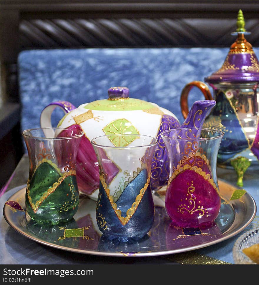 Two Moroccan teapots and three cups on a tray. Two Moroccan teapots and three cups on a tray