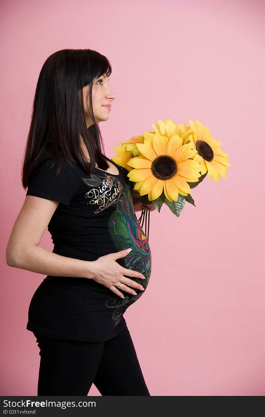 Pregnant woman holding belly with flowers