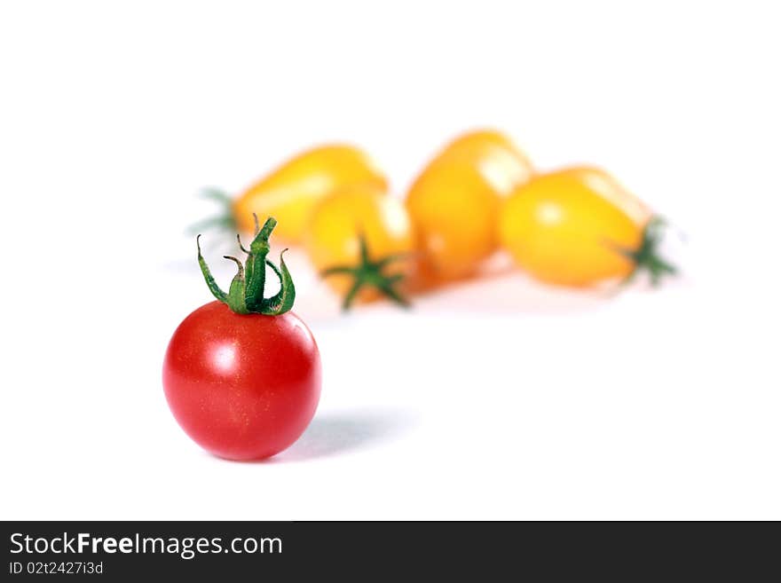 Red tomato against yellow tomatoes. Concept