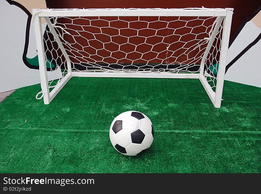 Soccer ball against the goal net in the grass. See more soccer photos in my portfoli. Soccer ball against the goal net in the grass. See more soccer photos in my portfoli