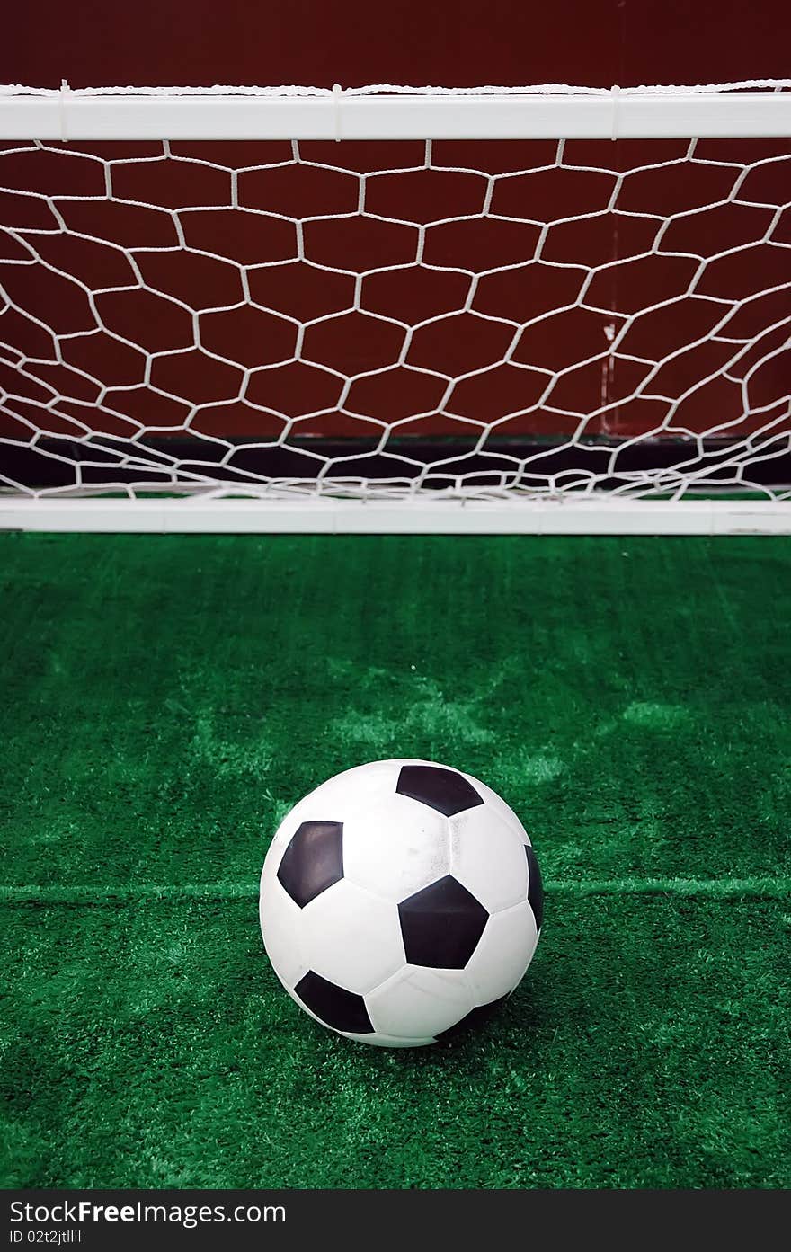 Soccer ball against the goal net in the grass. See more soccer photos in my portfoli. Soccer ball against the goal net in the grass. See more soccer photos in my portfoli