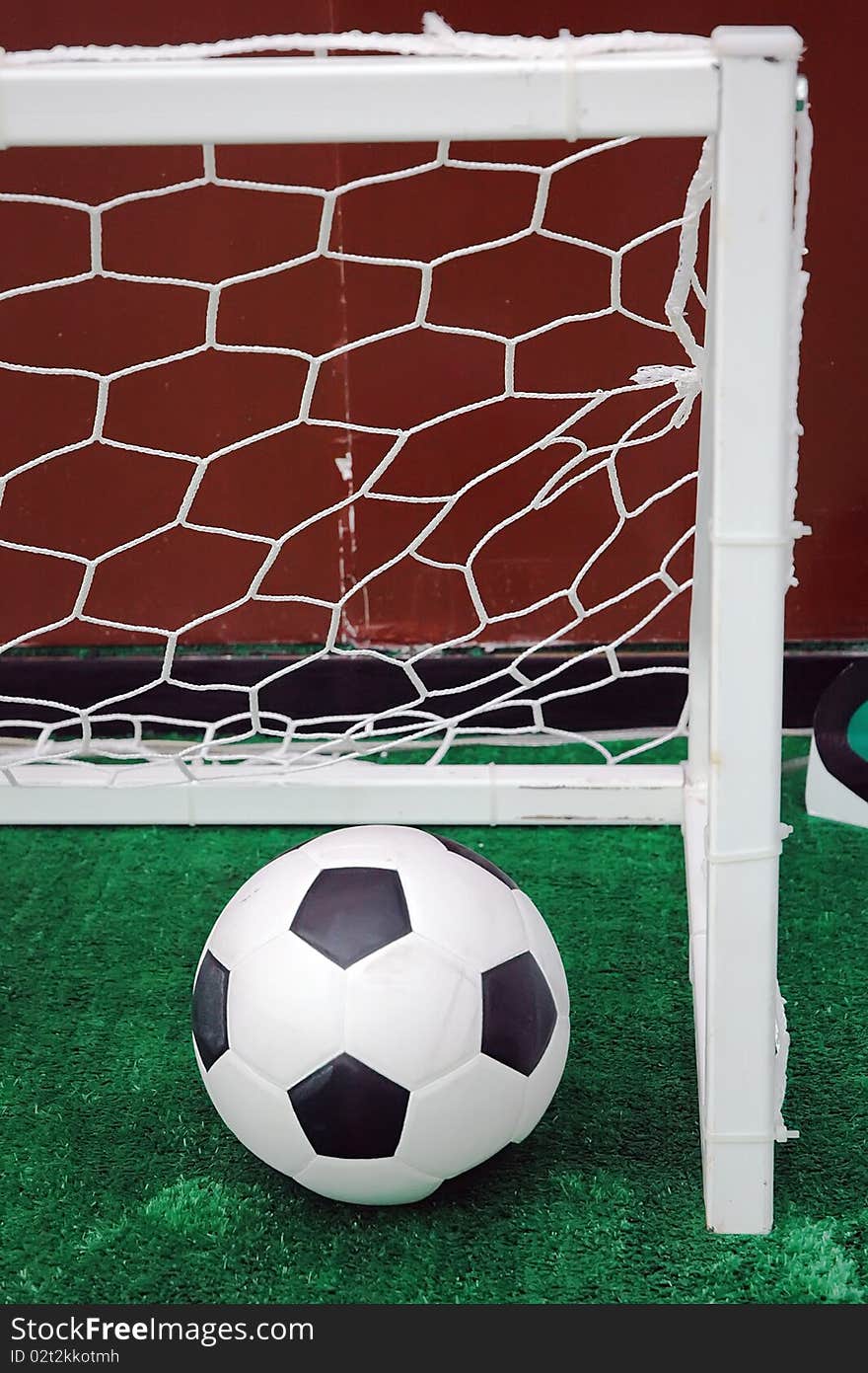 Soccer ball against the goal net in the grass. See more soccer photos in my portfoli. Soccer ball against the goal net in the grass. See more soccer photos in my portfoli