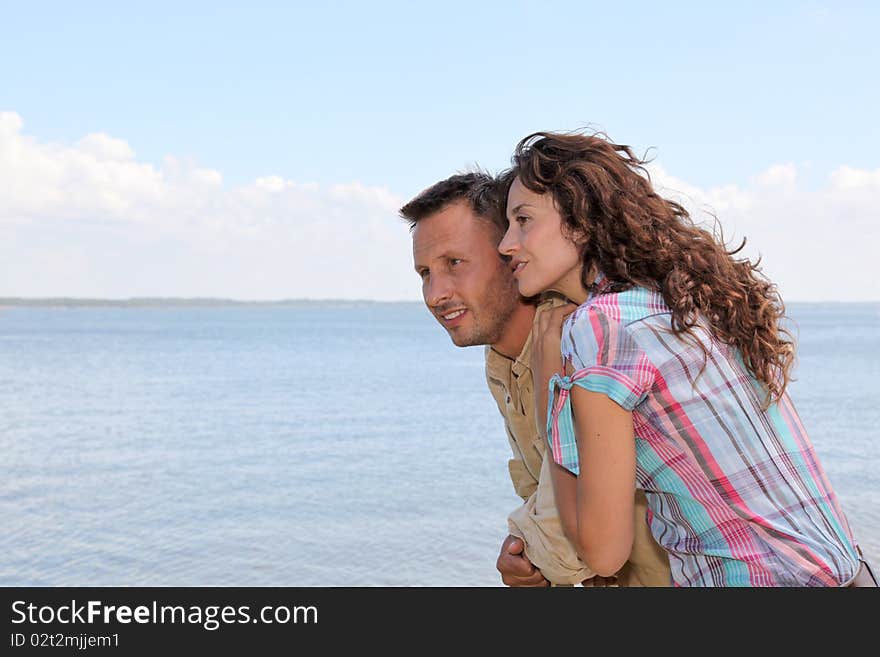 Loving couple standing on a pontoon by a lake. Loving couple standing on a pontoon by a lake